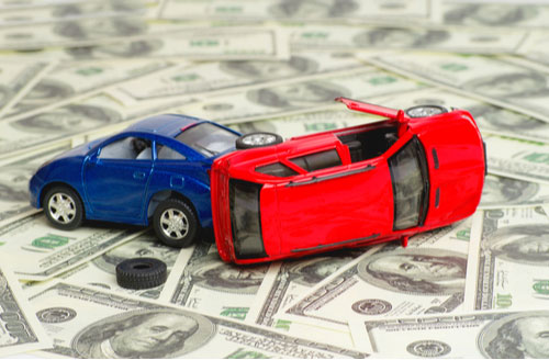 Concept of car accident lawyer cost, crashed toy cars on money