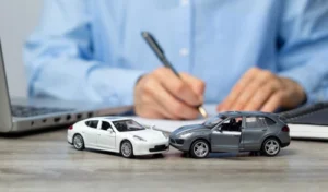 Attorney Signing Papers with Toy Cars - Underinsured Motorist