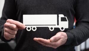 Person holding a cutout of a truck, symbolizing truck accident liability in Georgia personal injury law.