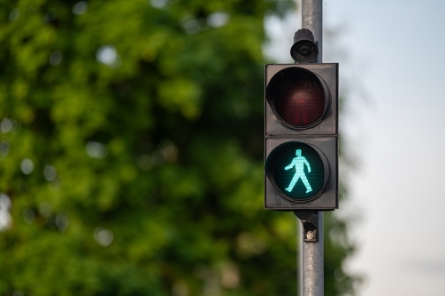 Crosswalk sign illuminated green for pedestrians to cross safely, data used in pedestrian accident lawyer cases