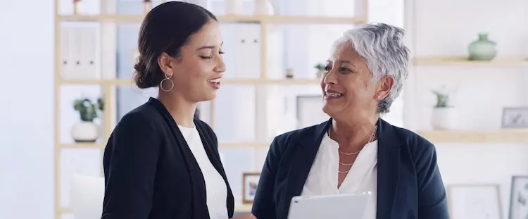 Two professional women are discussing legal documents representing injured victims, learning about their legal rights after truck accidents.