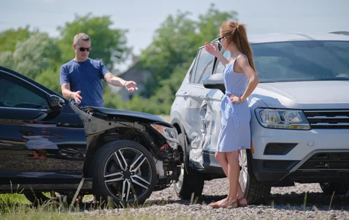 Woman and Man Standing by Crashed Cars