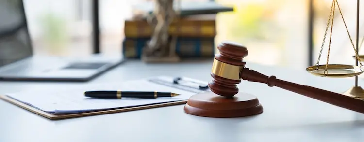 A judge's gavel with the scales of justice and legal documents symbolizing trucking company liability claims and personal injury lawsuits.