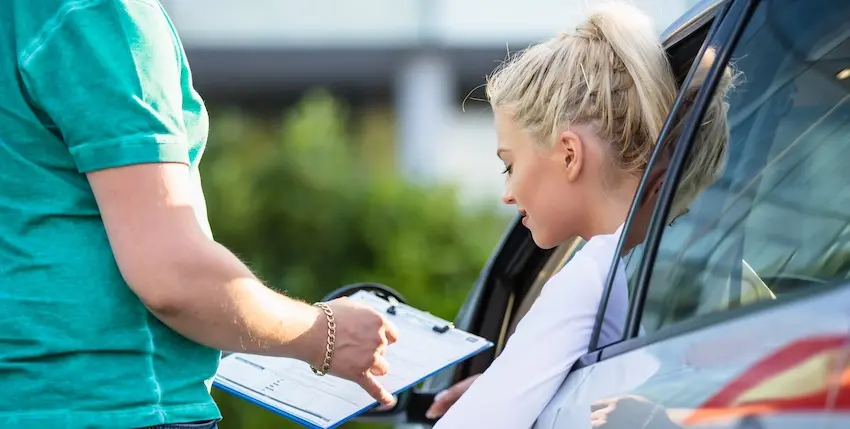 A medical professional is documenting injury information with a driver following delivery driver accidents in Georgia.