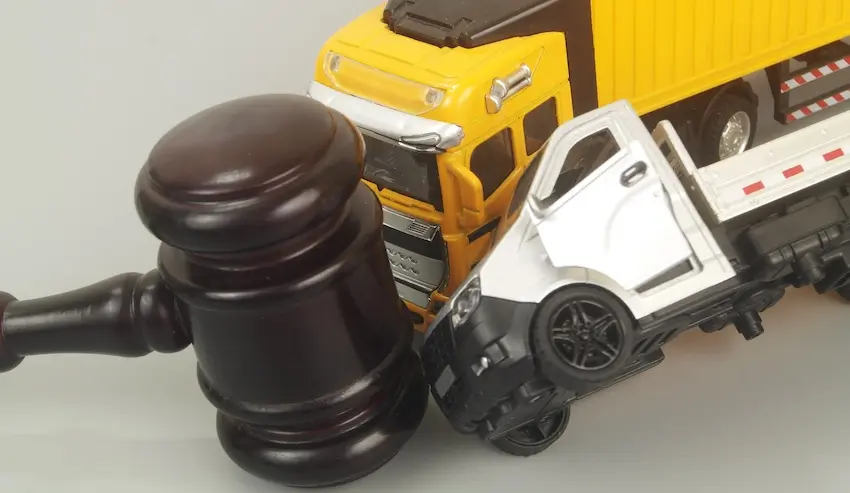 A legal gavel with two toy truck models represents litigation and compensation rights for truck accident victims in Georgia.