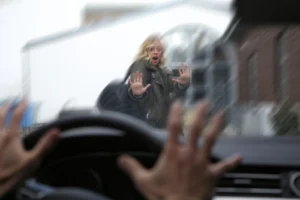 Woman crossing the street as an oncoming car nearly hits her illustrating situations handled by pedestrian accident lawyers