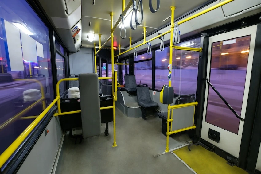 public bus interior with yellow rails