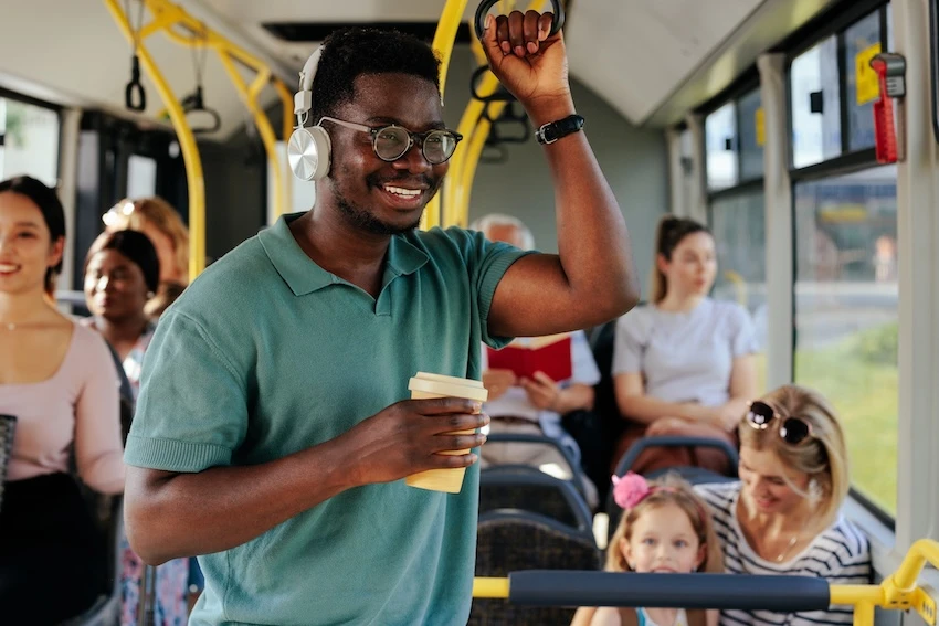 Young man holding on to a rail while on a Marta bus