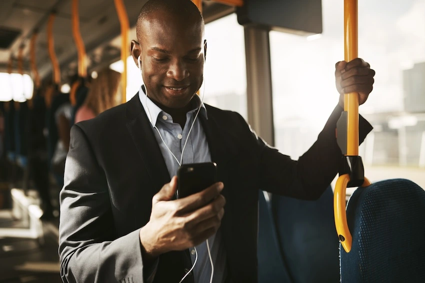 Man on hi sphone while riding a public bus