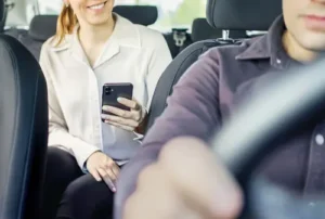 Pasajero sentado en el asiento trasero de un vehículo de viajes compartidos antes de un accidente de Uber o Lyft que necesita abogados de accidentes de viajes compartidos.