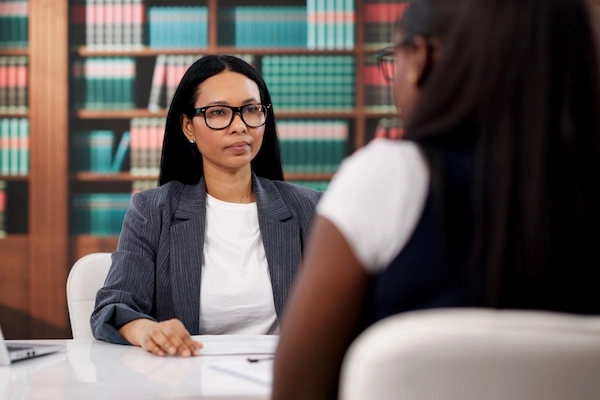 A motorcycle accident lawyer is speaking with a female client at 1Georgia Personal Injury Lawyers.